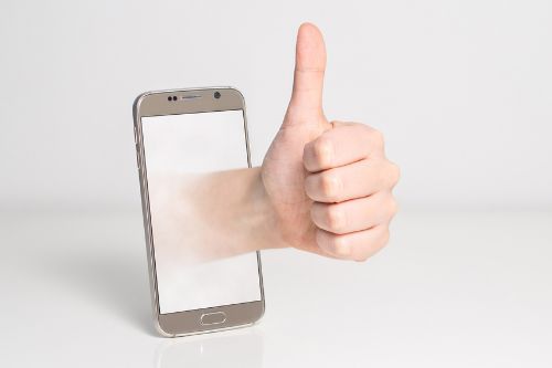 Daumen hoch Geste aus einen Handy. Die Hand kommt virtual aus dem Handy.