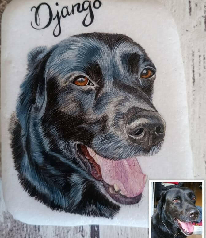 Ein Hundeportrait eines Labradors mit Namen, Geburtstag und Todestag des Tieres auf einem Gedenkstein. Neben dem Grabstein steht das Originalfoto des gemalten Hundes.