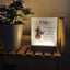 Fotolampen auf einem Regal mit einer Pflanze. Auf der LED Lampe ist ein Lieblingsfoto vom Hund und Trauerzitate. Das personalisierte Licht leuchtet hell.